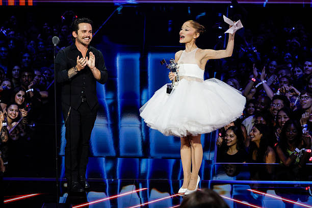 Ariana Grande accepts the Video of the Year award while director Christian Breslauer looks on at the 2025 MTV Video Music Awards at New York's UBS Arena in Elmont, N.Y. The show airs LIVE on the CBS Television Network and simulcast on MTV on Sunday, Sept. 7 , and streams on Paramount+. Photo credit: Mary Kouw/CBS ©2025 CBS Broadcasting, Inc. All Rights Reserved. — frame 22/78 (612×408)