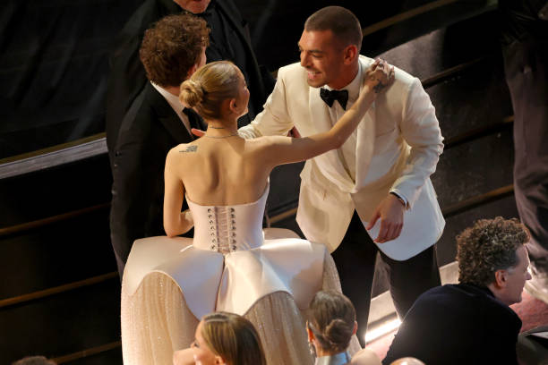 Ariana Grande and Matt Rogers speak in the audience during the 97th Annual Oscars at Dolby Theatre on March 02, 2025 in Hollywood, California. — frame 131/202 (612×408)
