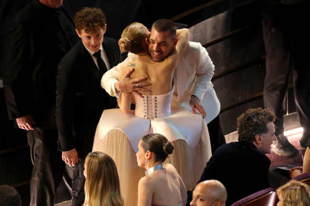 Ariana Grande and Matt Rogers speak in the audience during the 97th Annual Oscars at Dolby Theatre on March 02, 2025 in Hollywood, California. — frame 133/202 (612×408)