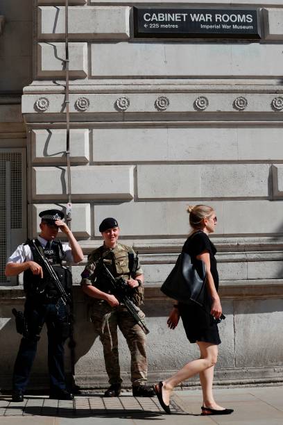 British army soldier stands alongside a police officer on Whitehall in central London on May 26 after Operation Temperer was put into force placing soldiers under police command on British streets in response to the May 22 terror attack at the Manchester Arena. Britain is hunting for a Libya-linked jihadist network thought to be behind the May 22 bombing at an Ariana Grande concert in Manchester, as US President Donald Trump threatened to prosecute anyone leaking details from the investigation to US media. / AFP PHOTO / Adrian DENNIS — frame 4/5 (408×612)