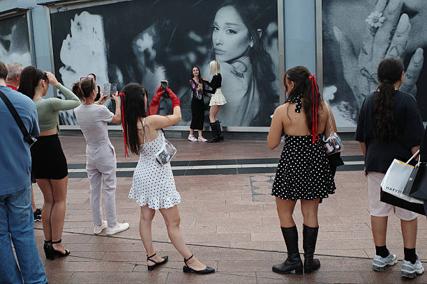 Ariana Grande fans pose for a photo in front of the 'Petal' album cover ahead of Ariana Grande's "The Eternal Sunshine T